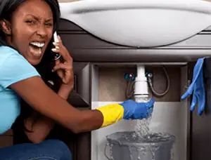 Emergency plumbing repair for a leaking sink drain under a bathroom vanity in Lexington, MA