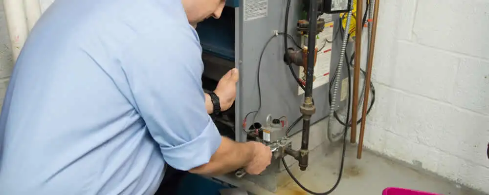 Furnace repair technician inspecting and servicing a home heating system in Lexington, MA