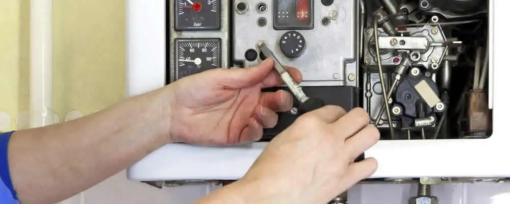 Heating repair technician adjusting boiler controls and components in Lexington, MA