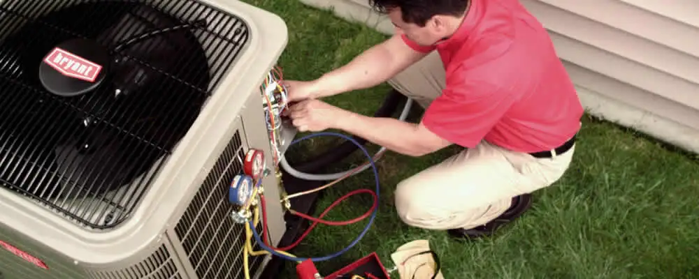 HVAC technician servicing an outdoor air conditioner unit in Lexington, MA