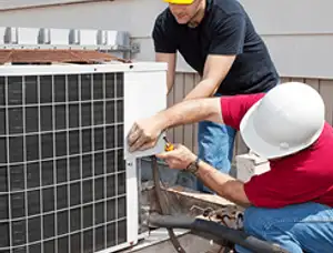 HVAC technicians repairing an outdoor AC unit on a rooftop in Lexington, MA