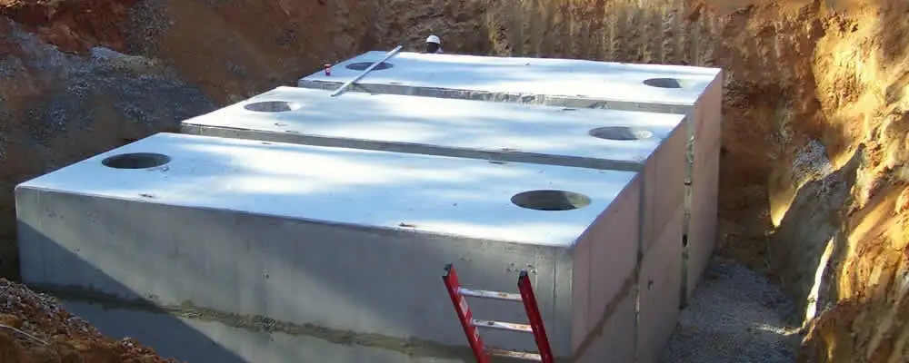 Septic tank installation site with a newly placed concrete tank in Lexington, MA
